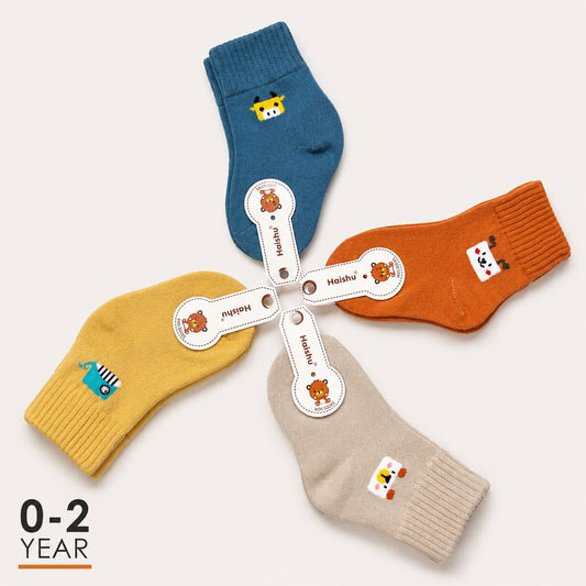 Four pairs of children's ankle socks arranged in a star pattern on a light beige background. The socks come in blue, orange, yellow, and beige colors, each decorated with a small cartoon animal graphic and a white elastic band with the brand name 'Heishu'.