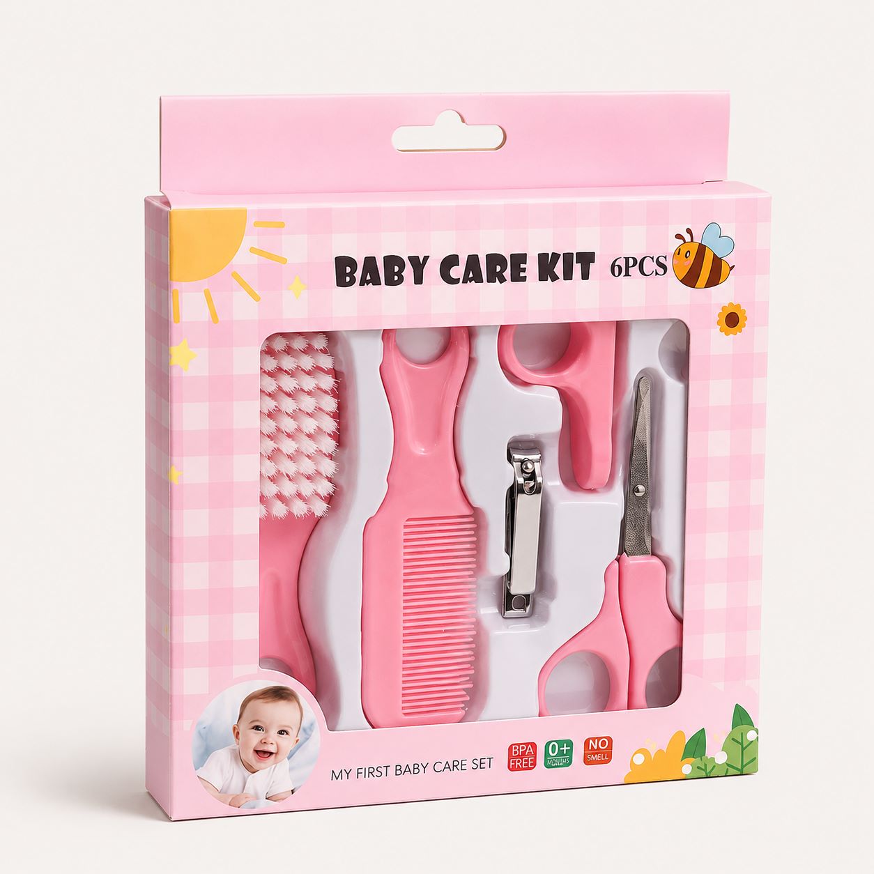 A pink baby care kit in its retail packaging, containing a baby toothbrush, nail comb, nail clipper, and nail scissors.
