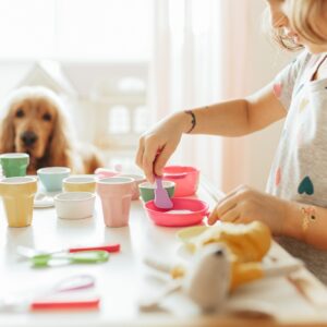 Little girl playing children tableware in children room
